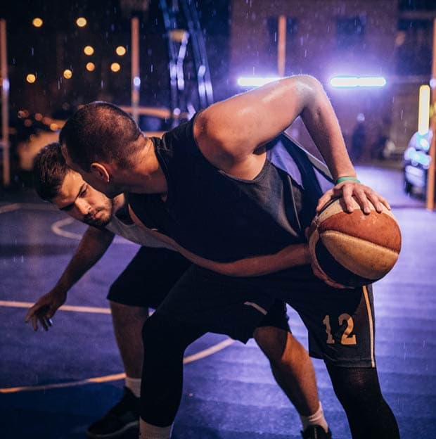 The bodies of 2 men playing basketball are scanned and then appear more boldly.